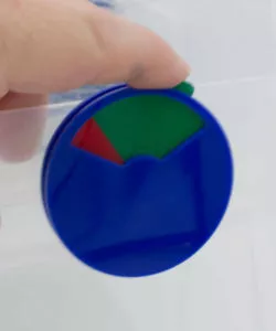 Hand holding blue plastic indicator dial with green and red slider | Maxpert Medical