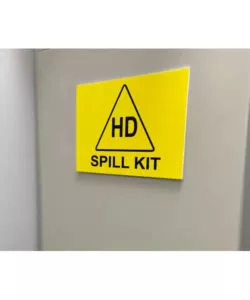 Bright yellow square hazardous drug spill kit sign on cabinet | Maxpert Medical